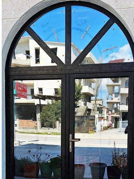Derë harku e zezë me xham në fasadë
